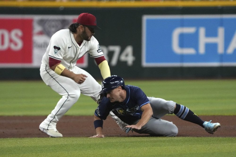 Tampa Bay Rays' Jake Mangum, right, gets tagged out by Arizona Diamondbacks third base Eugenio Suárez while trying to advance to third base in the fifth inning during a baseball game, Tuesday, April 22, 2025, in Phoenix. (AP Photo/Rick Scuteri)