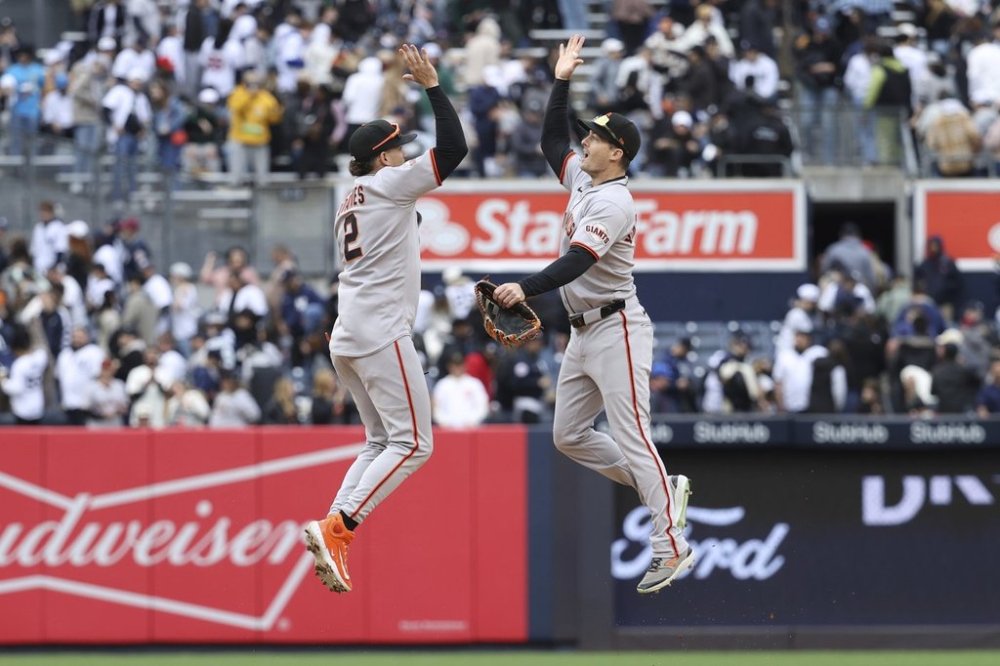 San Francisco Giants' Willy Adames, left, and Mike Yastrzemski, right, react after defeating the New York Yankees during a baseball game Sunday, April 13, 2025, in New York. (AP Photo/Pamela Smith)