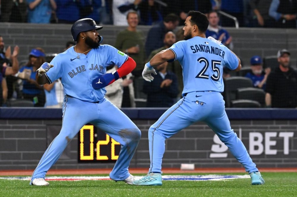 Toronto Blue Jays' Vladimir Guerrero Jr, left, and Anthony Santander (25) celebrate after Santander hit a three-run home run against the Boston Red Sox in seventh inning American League baseball action in Toronto on Wednesday, April 30, 2025. THE CANADIAN PRESS/Jon Blacker
