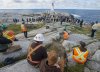 Construction workers look on at  the opening of a new viewing deck in Peggy's Cove, N.S. on Monday, Oct. 18, 2021. THE CANADIAN PRESS/Andrew Vaughan
