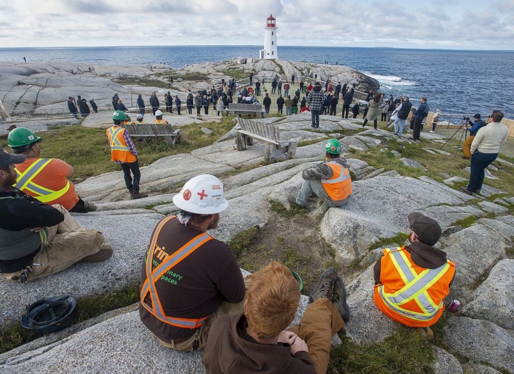 Construction workers look on at the opening of a new viewing deck in Peggy's Cove, N.S. on Monday, Oct. 18, 2021. THE CANADIAN PRESS/Andrew Vaughan