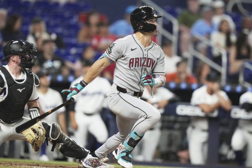 Arizona Diamondbacks' Corbin Carroll, right, watches after hitting a grand slam during the sixth inning of a baseball game against the Miami Marlins, Tuesday, April 15, 2025, in Miami. (AP Photo/Lynne Sladky)