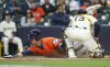 Houston Astros' Zach Dezenzo slides safety into home plate ahead of the tag by Milwaukee Brewers' Eric Haase (13) during the fifth inning of a baseball game, Wednesday, May 7, 2025, in Milwaukee. (AP Photo/Jeffrey Phelps)