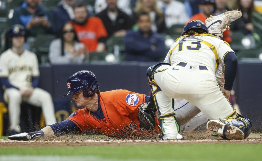 Houston Astros' Zach Dezenzo slides safety into home plate ahead of the tag by Milwaukee Brewers' Eric Haase (13) during the fifth inning of a baseball game, Wednesday, May 7, 2025, in Milwaukee. (AP Photo/Jeffrey Phelps)