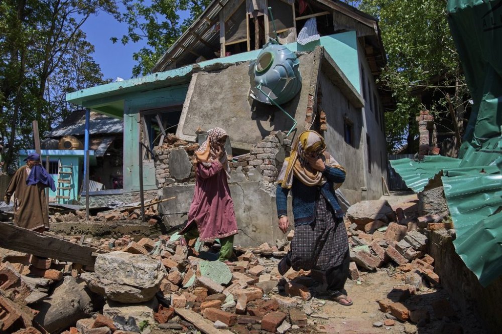 Kashmiri villager women walk past the blown-up family home of Asif Shiekh, a militant who officials all is involved in the deadly attack on tourists in Pahalgam, at Monghama village in Tral, south of Srinagar, Indian controlled Kashmir, Friday, April 25, 2025. (AP Photo/Dar Yasin)