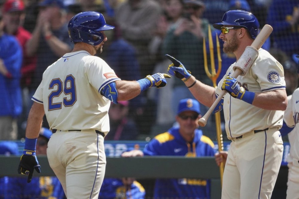 Seattle Mariners' Cal Raleigh (29) greets Luke Raley, right, after hitting a two-run home run against the Texas Rangers during the first inning of a baseball game Sunday, April 13, 2025, in Seattle. (AP Photo/Lindsey Wasson)