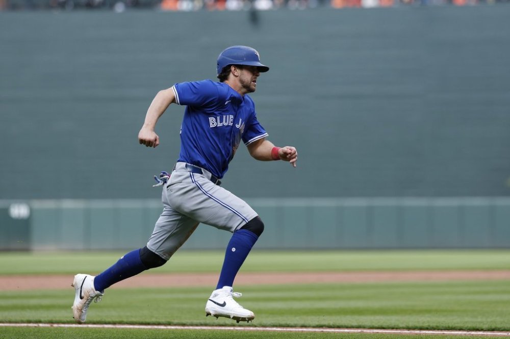 Toronto Blue Jays' Ernie Clement scores a run on a ball hit by Myles Straw against Baltimore Orioles pitcher Keegan Akin during the sixth inning of a baseball game in Baltimore, Sunday, April 13, 2025. (AP Photo/Terrance Williams)