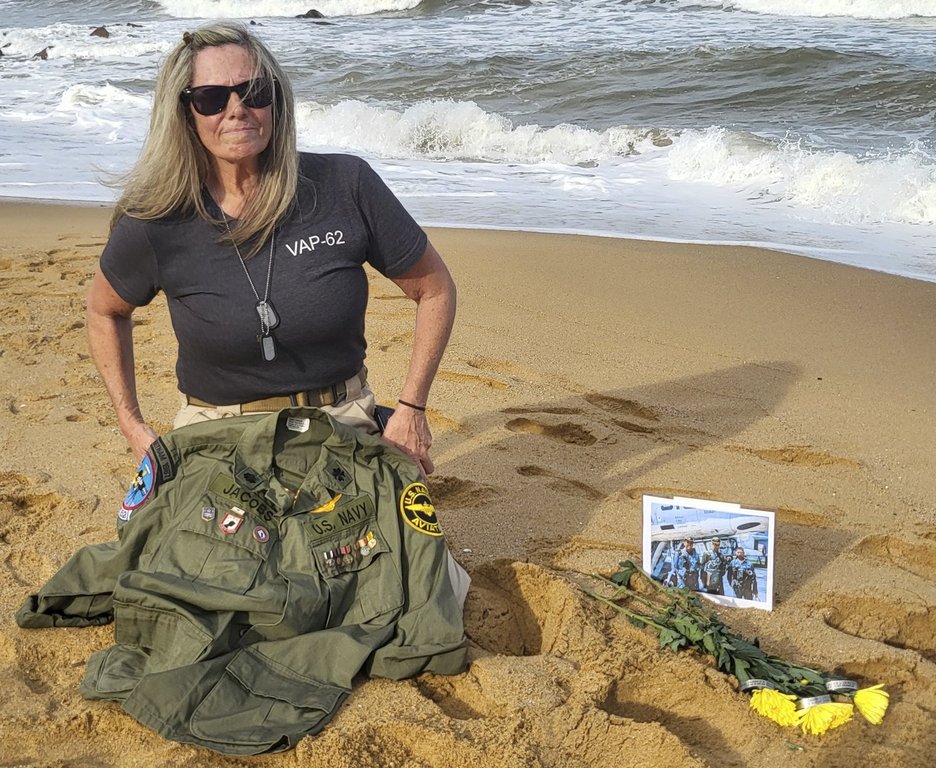 This photo provided by Jeanie Jacobs Huffman shows her on the beach in June 2024, two miles away from where her father's plane and crew were discovered in 70 feet of water, in Thanh Hoa Province, Vietnam. (Dave Huffman/Jeanie Jacobs Huffman via AP)