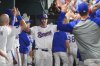 Texas Rangers' Corey Seager is sgreeted in the dugout after hitting a solo home run against the Los Angeles Angels during the seventh inning of a baseball game Thursday, April 17, 2025, in Arlington, Texas. (AP Photo/Julio Cortez)