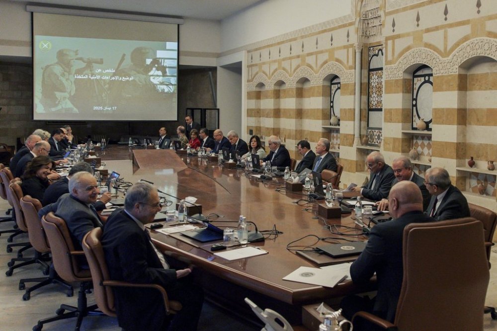In this photo, released by the Lebanese Presidency press office, Lebanese president Joseph Aoun, center foreground, and Lebanese Prime Minister Nawaf Salam, right, head a cabinet meeting at the presidential palace in Baabda, east of Beirut, Lebanon, Thursday, April 17, 2025. The Arabic on the screen reads,