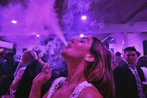 FILE - A guest takes a puff from a marijuana cigarette at the Sensi Magazine party celebrating the 420 holiday in the Bel Air section of Los Angeles, April 20, 2019. (AP Photo/Richard Vogel, File)