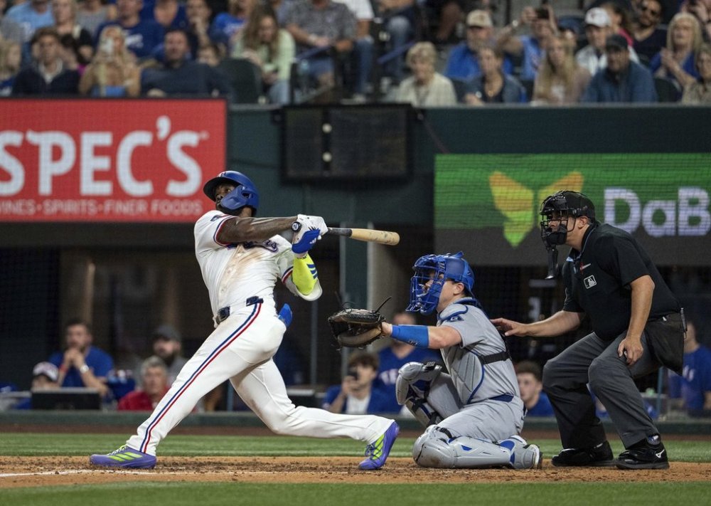 Texas Rangers' Adolis García follows through on a walk-off two run home run that scored Josh Smith off of Los Angeles Dodgers pitcher Kirby Yates during the ninth inning of a baseball game Saturday, April 19, 2025, in Arlington, Texas. (AP Photo/Jeffrey McWhorter)