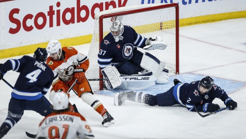 Winnipeg Jets' Dylan DeMelo (2) goes down to block the shot in front of goaltender Connor Hellebuyck (37) as Neal Pionk (4) defends against Anaheim Ducks' Troy Terry (19) during second period NHL action in Winnipeg on Wednesday, April 16, 2025. THE CANADIAN PRESS/John Woods