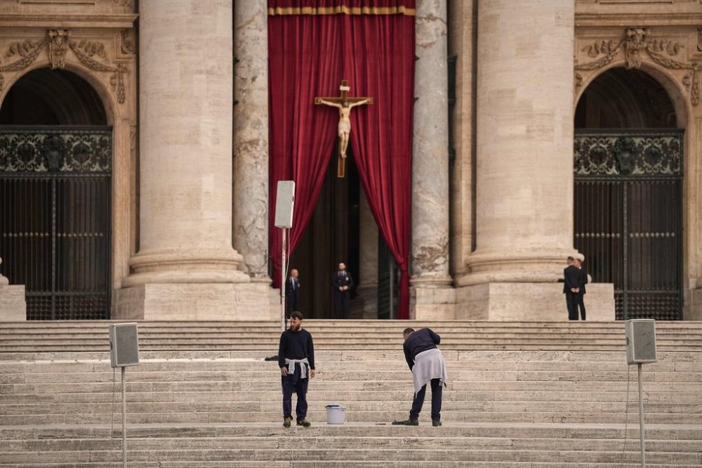 Men wash the steps St. Peter's Basilica before the arrival of the body of Pope Francis, who will lie in state at for three days, at the Vatican, Wednesday, April 23, 2025. (AP Photo/Andreea Alexandru)
