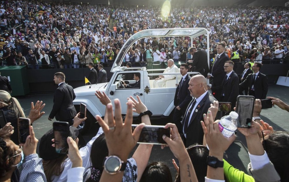 People gather to get a closer look as Pope Francis arrives for mass in Edmonton during his visit to Canada on Tuesday, July 26, 2022. THE CANADIAN PRESS/Jason Franson.
