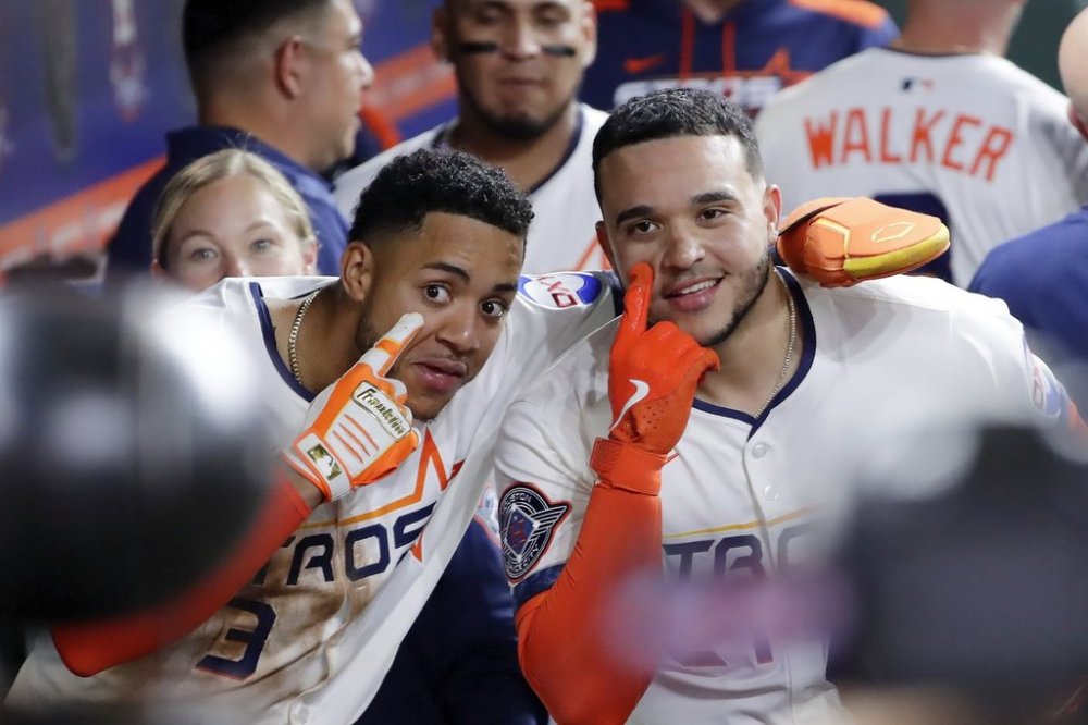 Houston Astros Jeremy Pena (3) and Yainer Diaz, right, mug for the cameras in the dugout as they celebrate after a grand slam by Diaz against the Los Angeles Angels during the fifth inning of a baseball game Friday, April 11, 2025, in Houston. (AP Photo/Michael Wyke)