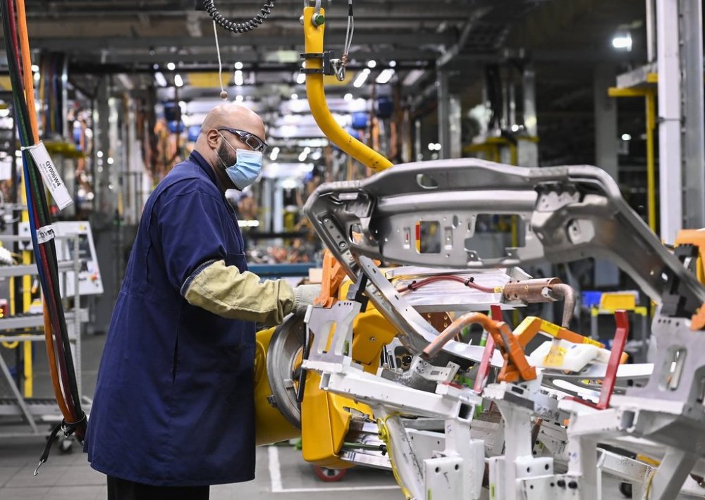 GM workers use human assisted automation to weld vehicle doors at the General Motors assembly plant in Oshawa, Ont., on Friday, March 19, 2021. THE CANADIAN PRESS/Nathan Denette