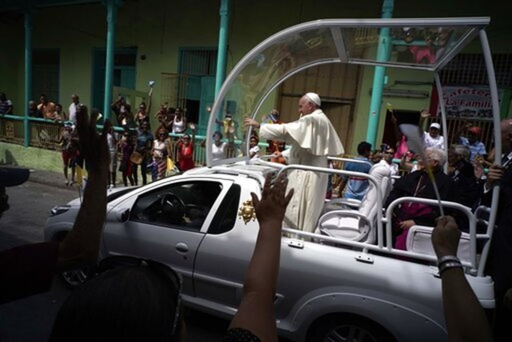 FILE - People wave to Pope Francis as he leaves the Metropolitan Cathedral, in route to the airport in Santiago de Cuba, Cuba, on Tuesday, Sept. 22, 2015. (AP Photo/Ramon Espinosa, file)