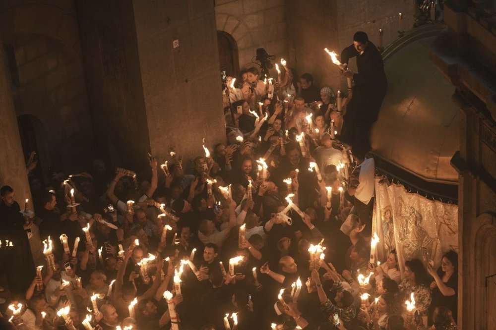 Christian pilgrims light candles during the Holy Fire ceremony, at the Church of the Holy Sepulcher, the site where according to tradition Jesus was crucified and buried, in Jerusalem's Old City, Saturday, April 19, 2025. (AP Photo/Mahmoud Illean)