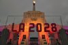 FILE - An LA 2028 sign is seen in front of the Olympic cauldron at the Los Angeles Memorial Coliseum, Wednesday, Sept. 13, 2017. (AP Photo/Richard Vogel, File)