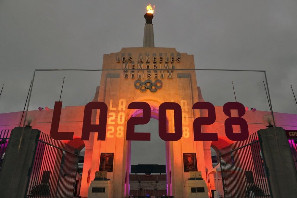 FILE - An LA 2028 sign is seen in front of the Olympic cauldron at the Los Angeles Memorial Coliseum, Wednesday, Sept. 13, 2017. (AP Photo/Richard Vogel, File)