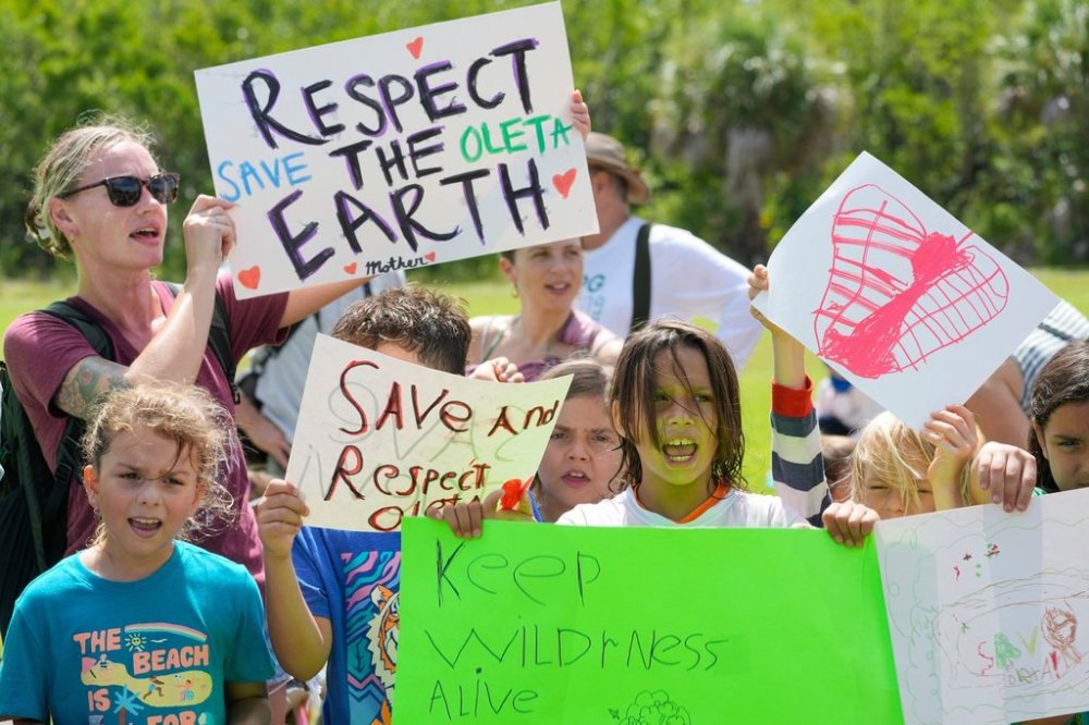 FILE - Protesters chant against Gov. Ron DeSantis' plan to develop state parks with business ventures such as golf courses, pickleball courts and large hotels, during a demonstration at Oleta River State Park, Tuesday, Aug. 27, 2024, in North Miami Beach, Fla. (AP Photo/Wilfredo Lee, File)