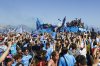 The crowd cheers as Napoli players celebrate winning their fourth Serie A soccer league title in an open-air bus parade alongside Naples' seafront with Mt. Vesuvius in the background, in Naples, Italy, Monday, May 26, 2025. (Antonio Balasco/LaPresse via AP)