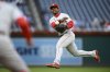 FILE - Philadelphia Phillies second baseman Jean Segura throws to first but is unable to get Washington Nationals' CJ Abrams who singled during the eighth inning of the first baseball game of a doubleheader, Oct. 1, 2022, in Washington. (AP Photo/Nick Wass, File)