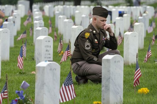 FILE - A member of the Army visits Section 60 of Arlington National Cemetery, in Arlington, Va., Monday, May 27, 2024, on Memorial Day. (AP Photo/Jacquelyn Martin, File)