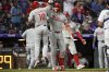 Philadelphia Phillies' J.T. Realmuto (10) and Alec Bohm (28) celebrate after Realmuto's two-run home run in the sixth inning of a baseball game against the Colorado Rockies Wednesday, May 21, 2025, in Denver. (AP Photo/Geneva Heffernan)