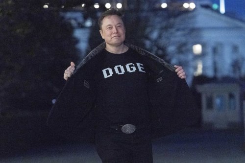 Elon Musk flashes his t-shirt that reads 
