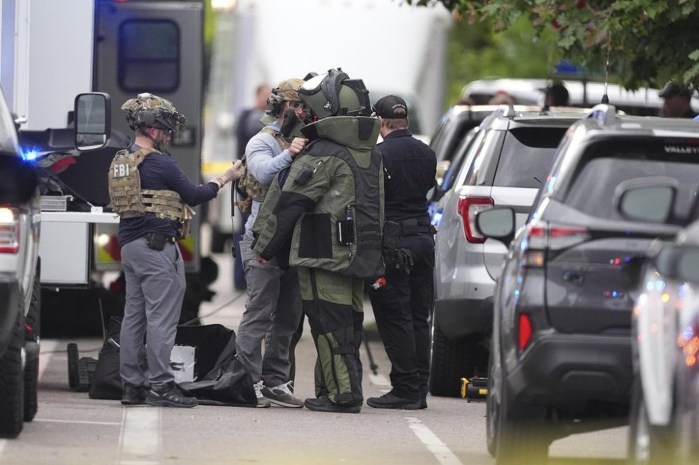 Law enforcement officials dress to investigate after an attack on the Peark Street Mall Sunday, June 1, 2025, in Boulder, Colo. (AP Photo/David Zalubowski)