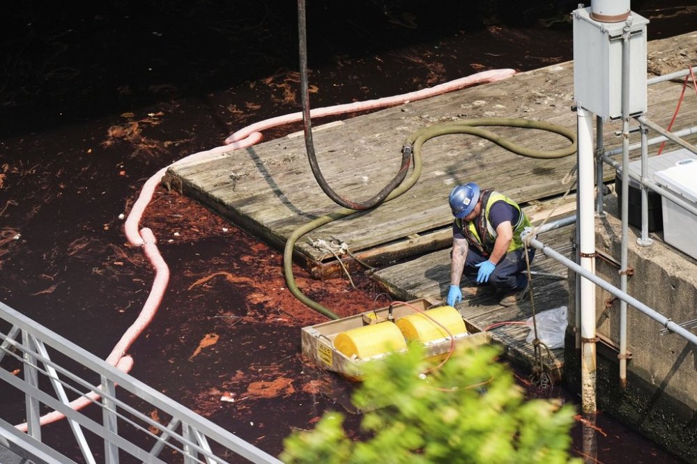 A crew member works to clean up and contain a 2,000-gallon diesel fuel spill in the Baltimore Harbor, Thursday, June 5, 2025, in Baltimore. (AP Photo/Stephanie Scarbrough)