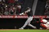 Miami Marlins' Connor Norby, left, hits a three-run home run as Los Angeles Angels catcher Logan O'Hoppe watches during the seventh inning of a baseball game Saturday, May 24, 2025, in Anaheim, Calif. (AP Photo/Mark J. Terrill)