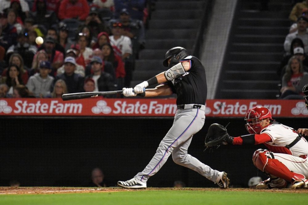 Miami Marlins' Connor Norby, left, hits a three-run home run as Los Angeles Angels catcher Logan O'Hoppe watches during the seventh inning of a baseball game Saturday, May 24, 2025, in Anaheim, Calif. (AP Photo/Mark J. Terrill)