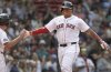 Boston Red Sox's Rafael Devers, right, is all smiles as he heads to the dugout after after hitting a home run during the seventh inning of a baseball game against the Texas Rangers, Thursday, May 8, 2025, in Boston. (AP Photo/Jim Davis)