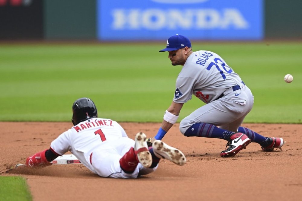 Cleveland Guardians' Angel Martinez slides safely into second base for a double as Los Angeles Dodgers second baseman Miguel Rojas misplays the baseball during the first inning of a baseball game, Wednesday, May 28, 2025, in Cleveland. (AP Photo/David Dermer)