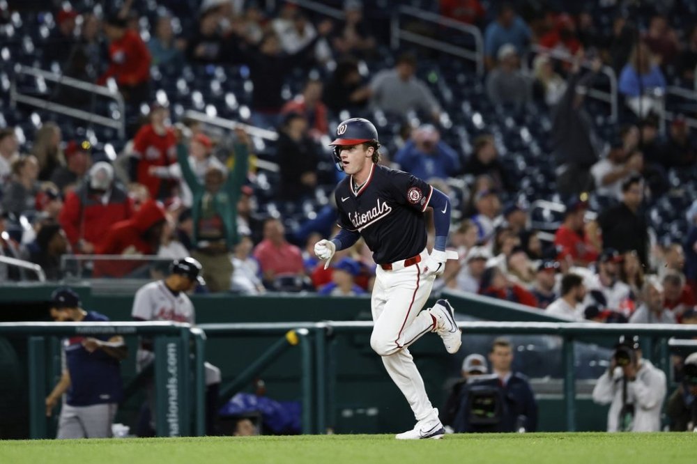 Washington Nationals' Robert Hassell III scores the game winning run on a single hit by Amed Rosario against Atlanta Braves pitcher Dylan Lee during the tenth inning of a baseball game in Washington, Thursday, May 22, 2025. (AP Photo/Terrance Williams)