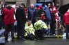 A police officer speaks with a man at the site of an incident on Water Street near the Liver Building in Liverpool after a car collided with pedestrians during the Premier League winners parade, in Liverpool, England, Monday May 26, 2025. (Owen Humphreys/PA via AP)
