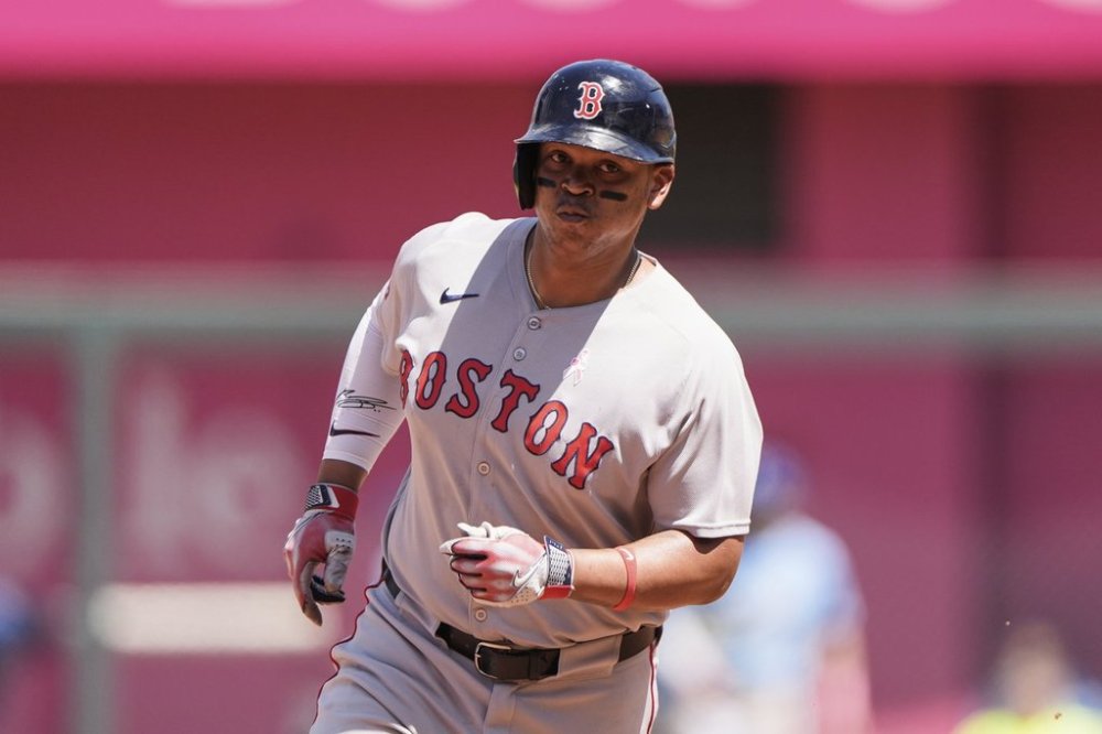 Boston Red Sox's Rafael Devers, right, runs home to score after hitting a two-run home run during the sixth inning of a baseball game against the Kansas City Royals, Sunday, May 11, 2025, in Kansas City, Mo. (AP Photo/Charlie Riedel)