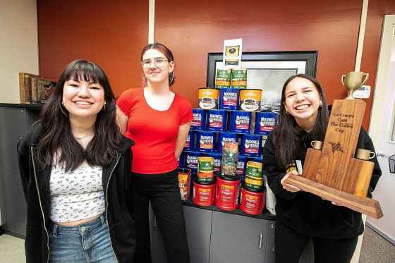 Collège Béliveau leadership students Aislyn Chester (left), Eliza Honke, and Audrina Wavey with the coffee collected through the school coffee drive on Thursday. (Mikaela MacKenzie / Free Press)