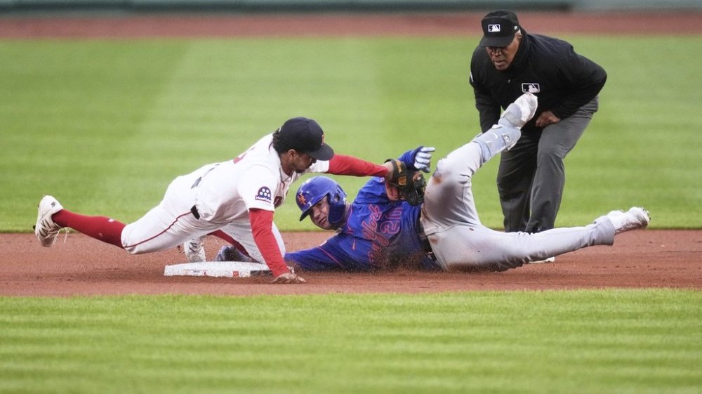 Boston Red Sox second baseman David Hamilton, left, tags out New York Mets' Pete Alonso, center, who was trying to advance to second on his single during the first inning of a baseball game at Fenway Park, Monday, May 19, 2025, in Boston. (AP Photo/Charles Krupa)
