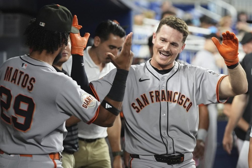 San Francisco Giants' Matt Chapman, right, reacts after hitting a solo home run during the fourth inning of a baseball game against the Miami Marlins, Friday, May 30, 2025, in Miami. (AP Photo/Lynne Sladky)