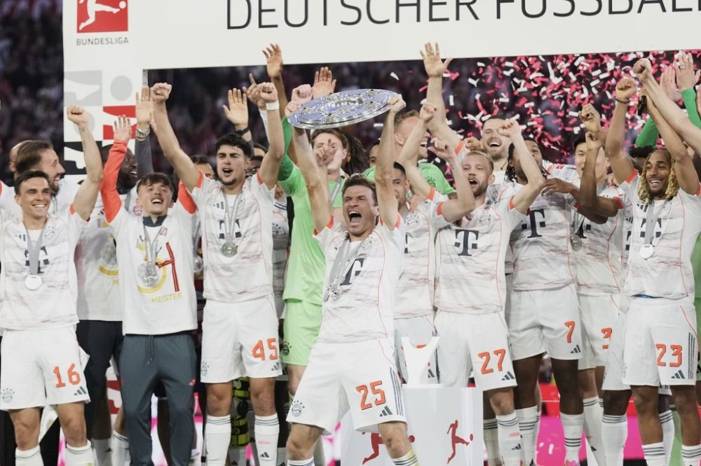 Bayern's Thomas Mueller, centre, celebrates with the championship shield after the German Bundesliga soccer match between FC Bayern Munich and Borussia Moenchengladbach in Munich, Germany, Saturday, May 10, 2025. (AP Photo/Matthias Schrader)