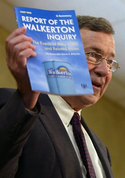 Justice Dennis O'Connor holds up a copy of the summary of the 