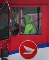 A Canada Post employee drives a mail truck at a delivery depot in Vancouver, B.C., Tuesday, Dec. 17, 2024. Canada Post trucks, conveyors and mail carriers are moving again after a month-long strike by more than 55,000 postal workers left letters and parcels in limbo. THE CANADIAN PRESS/Darryl Dyck
