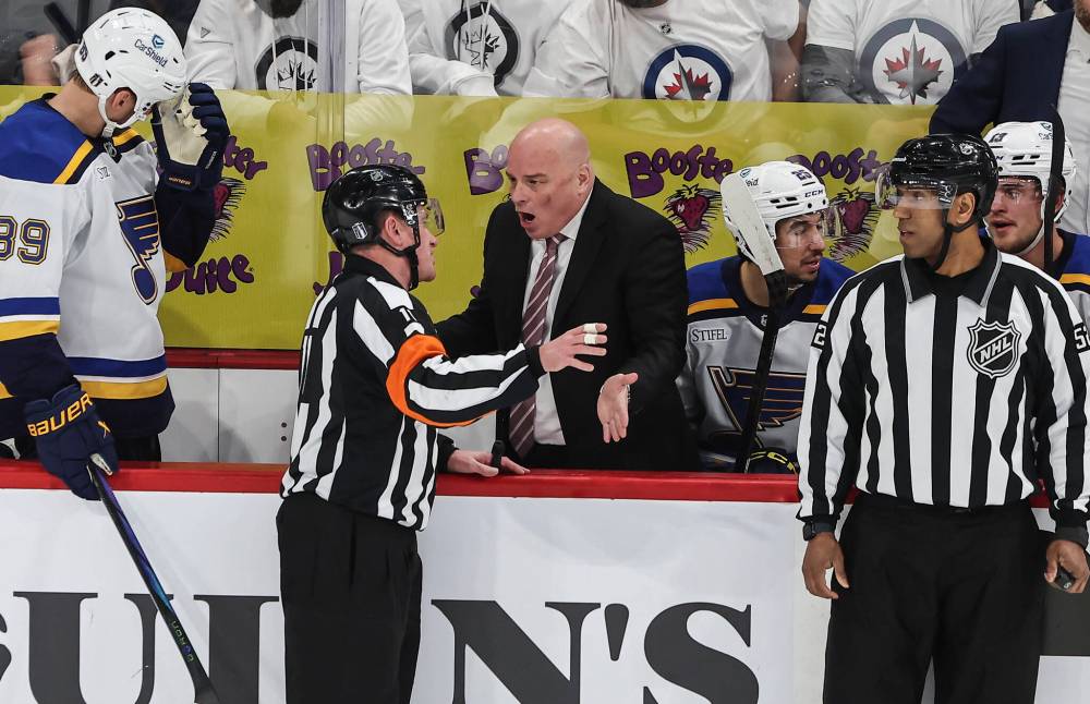 St. Louis Blues head coach Jim Montgomery questions referee Kelly Sutherland during first period NHL playoff action against the Winnipeg Jets in Winnipeg on Wednesday. (John Woods / The Canadian Press)