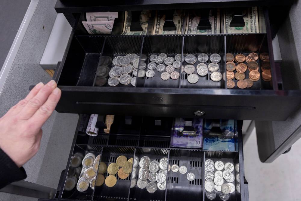 RYAN SUN / THE ASSOCIATED PRESS FILES
A cashier at the International Market in Point Roberts, Wash., displays a till for U.S. and Canadian dollars.