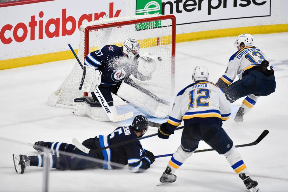 St. Louis Blues’ Radek Faksa (12) scores on Winnipeg Jets goaltender Connor Hellebuyck (37) during the second period. (Fred Greenslade / The Canadian Press)