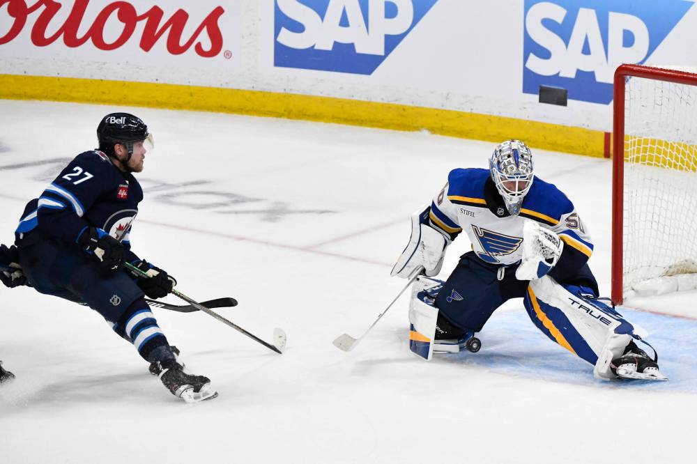 St. Louis Blues goaltender Jordan Binnington (50) makes a save on Winnipeg Jets’ Nikolaj Ehlers (27) during the first overtime period. (Fred Greenslade / The Canadian Press)